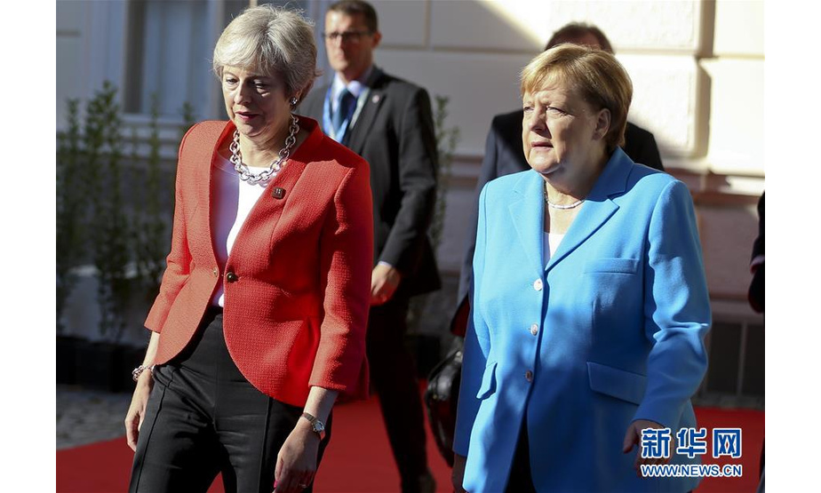 9月20日，在奥地利萨尔茨堡，英国首相特雷莎·梅（左）与德国总理默克尔抵达欧盟非正式峰会现场。 欧盟非正式峰会19日在奥地利西部城市萨尔茨堡开幕。 新华社记者 叶平凡 摄