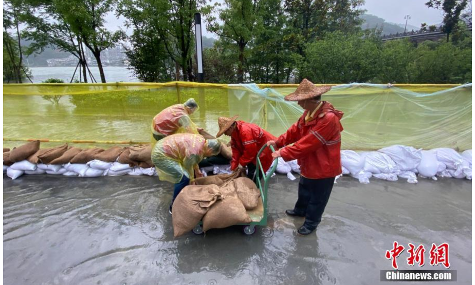 多位救援人员在新安江边堆放沙袋预防洪水。中新社记者 王刚 摄
