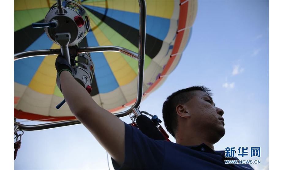 7月25日，在台湾台东鹿野高台，徐玉儒驾驶热气球飞在空中，在观察地形、风向的同时控制着燃烧器。 新华社记者 吴鲁 摄