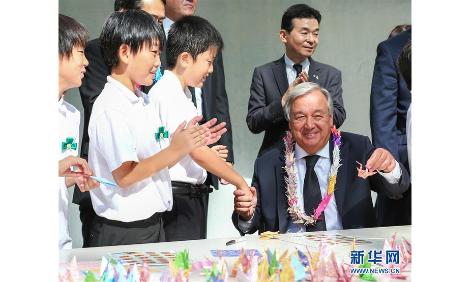 8月9日，在日本长崎，联合国秘书长古特雷斯（前右）和当地儿童一起叠纸鹤。 新华社记者 马曹冉 摄