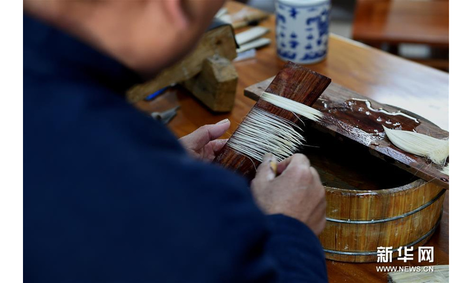 12月4日，佘征军在泾县“守艺人”工作室进行宣笔制作的齐毫工序。新华社发（周牧 摄）