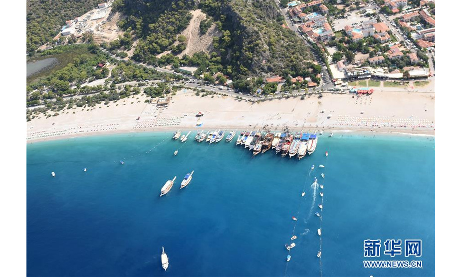 这是2018年7月23日在土耳其西南部的费特希耶拍摄的海滩和游船。 6月5日是第47个联合国世界环境日，今年的主题为“关爱自然 刻不容缓”。 新华社记者 贺灿铃 摄