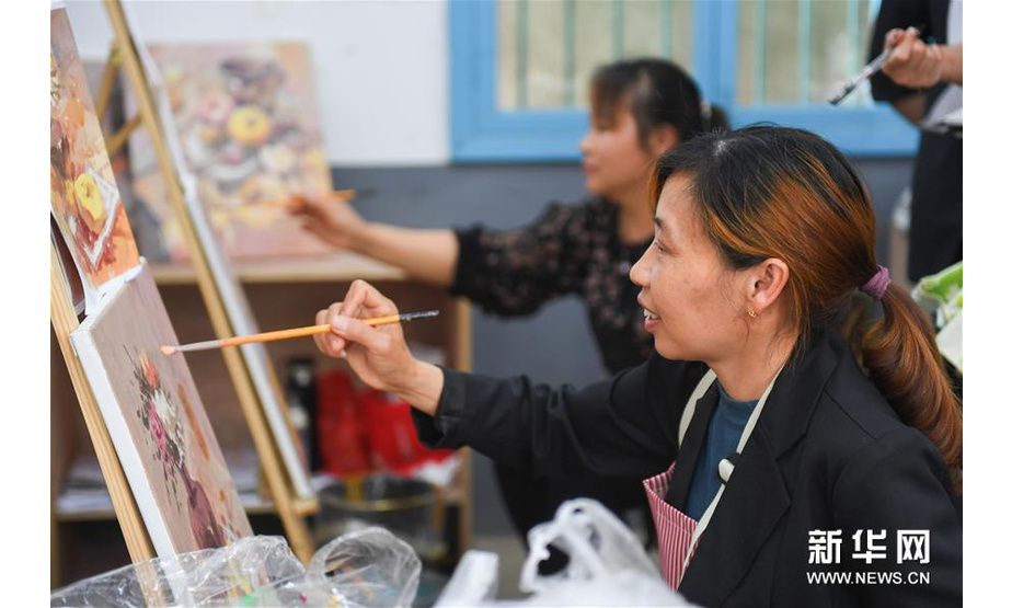 5月13日，在浏阳市小河乡乌石村，村民在绘制油画。新华社记者 陈泽国 摄