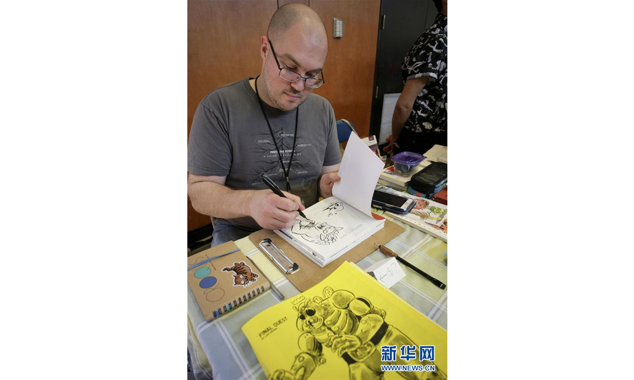 5月20日，在加拿大温哥华，一名漫画家在漫画艺术节上作画。 2018温哥华漫画艺术节于5月19日至20日举行，数百名漫画家来此展出他们的作品，吸引众多漫画爱好者前来参观交流。 新华社发（梁森摄）