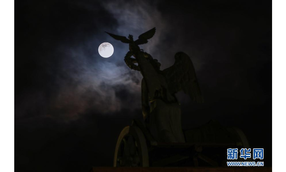 这是2月26日在德国首都柏林勃兰登堡门拍摄的满月。

　　新华社记者 单宇琦 摄