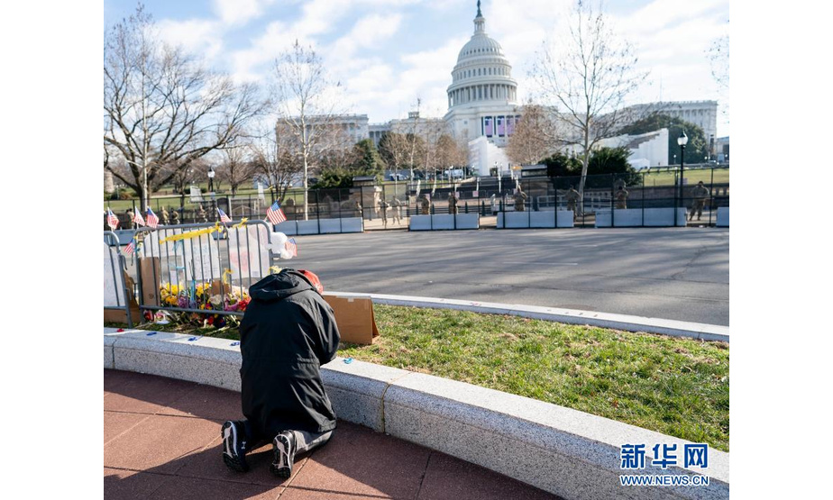 1月13日，在美国首都华盛顿，一名男子在国会大厦附近祈祷。新华社记者 刘杰 摄