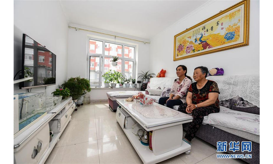苏艳梅（后）和婆婆李秀珍在阿尔山市伊尔施街道伊林小区新居中看电视（8月11日摄）。新华社记者 刘磊 摄