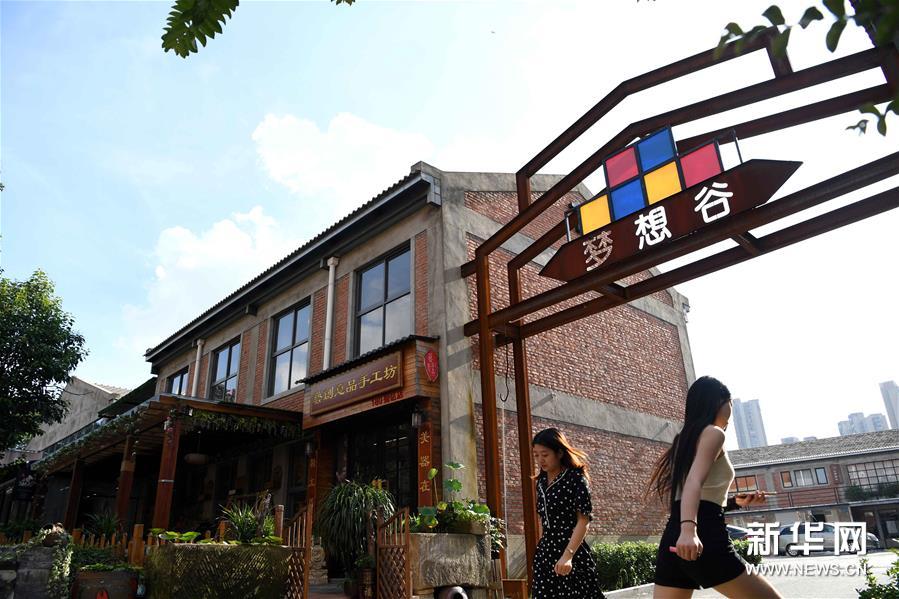 8月4日，人们走在合肥长江180艺术街区。合肥市瑶海区长江180艺术街区所在地原是一片工业厂房，为有效利用老工业厂房，保留工业文化特色，当地在旧厂房内注入现代元素，将其打造成为集创意办公、文创展示、公共阅读、体育健身等功能为一体的文创园区。新华社发（解琛 摄）