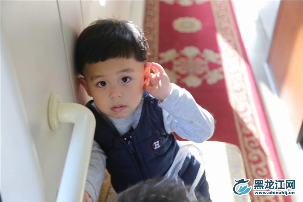 手指摸着耳朵，面容略带羞涩。 石启立 摄