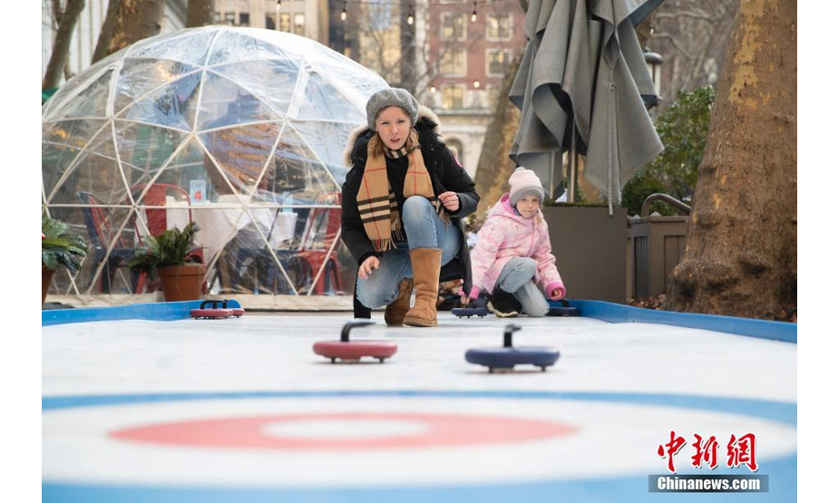 当地时间1月23日，美国纽约布莱恩公园一家餐厅在户外设置模拟冰壶运动装置，顾客用餐间隙可以享受冬季运动乐趣。随着严冬来临，纽约冬季运动升温。 中新社记者 廖攀 摄