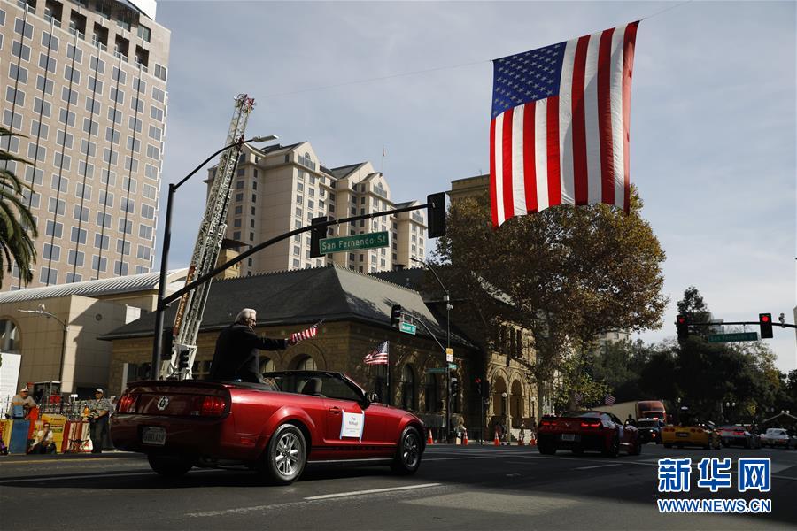 11月11日，在美国加利福尼亚州圣何塞，参加退伍军人纪念日游行的队伍经过一面美国国旗。 当日，美国加利福尼亚州旧金山湾区城市圣何塞举行退伍军人纪念日游行。 新华社发（李建国摄）