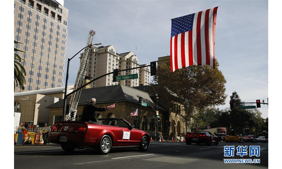 11月11日，在美国加利福尼亚州圣何塞，参加退伍军人纪念日游行的队伍经过一面美国国旗。 当日，美国加利福尼亚州旧金山湾区城市圣何塞举行退伍军人纪念日游行。 新华社发（李建国摄）