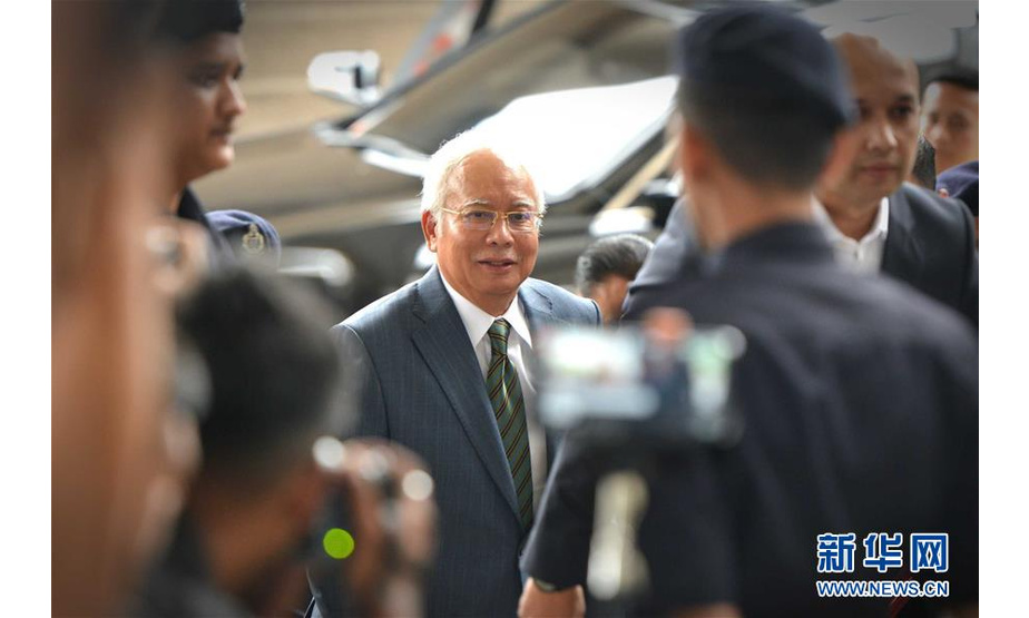 8月8日，在马来西亚吉隆坡，马来西亚前总理纳吉布（中）抵达法院。 新华社发（张纹综摄）