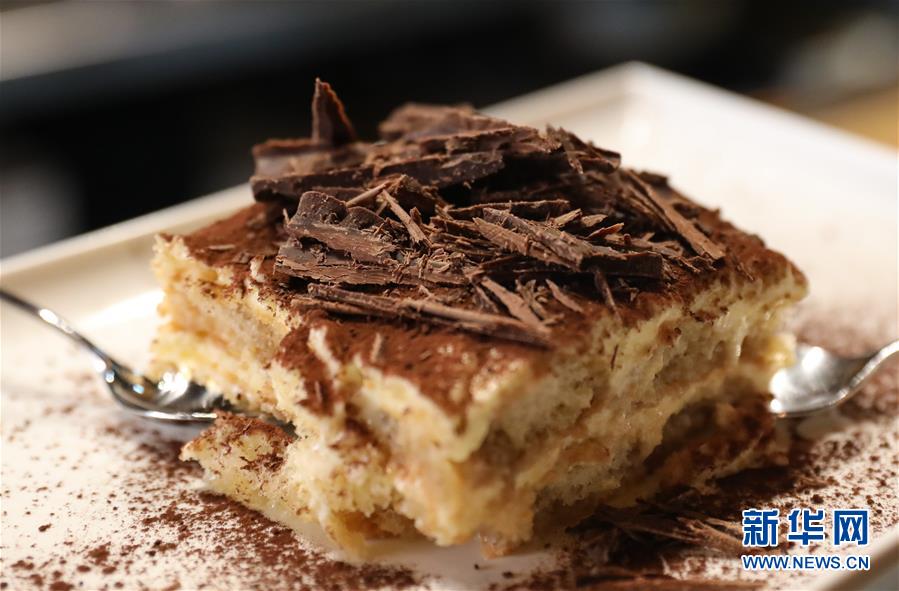 这是8月23日在意大利首都罗马的一家餐厅拍摄的一块经典口味的提拉米苏。提拉米苏是意大利传统甜品，且深受世界各地人民的喜爱。经典的意式提拉米苏由马斯卡彭奶酪、手指饼干、蛋黄、咖啡、可可粉等原料制成。浸泡过咖啡的手指饼与奶酪糊相互叠加，最上层撒上咖啡粉，再洒上一些碎巧克力；挖一勺送入口中，奶酪的丰盈细滑与湿润的手指饼干的颗粒感混合在一起，甜的滋味刚一涌出便由咖啡的苦来平衡，即使正餐吃了再多的意大利面也无法拒绝这样一道美味的甜品。除了经典口味，开心果口味，各式水果口味的提拉米苏也受到越来越多的欢迎。新华社记者 程婷婷 摄