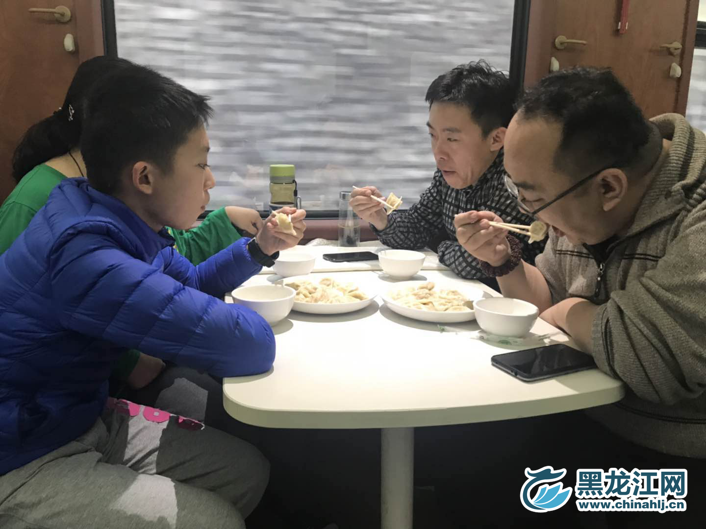 小伙子好奇的看了下咬开的饺子，琢磨着里面到底是什么馅儿的。宋菲 摄