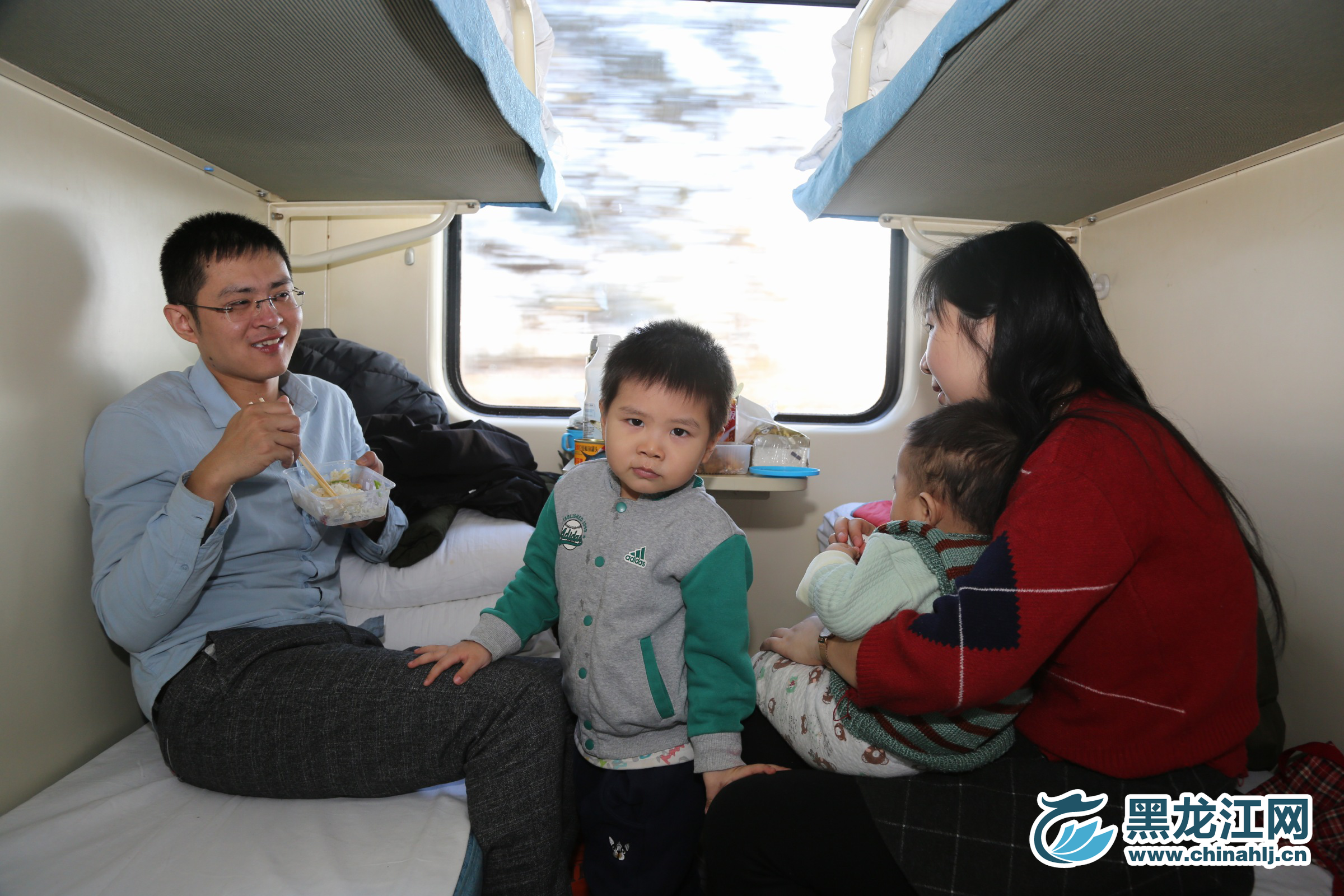 年轻的父亲，望着妻儿微笑着。 石启立 摄