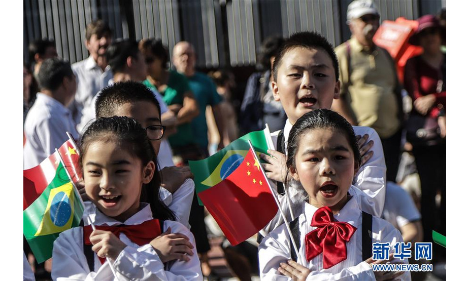 8月11日，小演员在巴西圣保罗市保利斯塔大街手持两国国旗演唱。 “《我和我的祖国》中华文化快闪活动”11日在巴西圣保罗市保利斯塔大街举行。百余名华侨华人和巴西民众观看了演出。 新华社发（拉赫尔·帕特拉索摄）