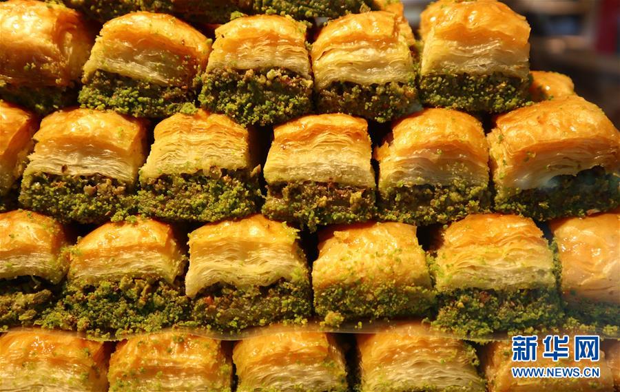 这是8月18日在土耳其伊斯坦布尔塔克西姆广场的一家甜品店拍摄的“巴克拉瓦”。果仁蜜饼“巴克拉瓦”是土耳其民众最喜爱的传统甜点之一。“巴克拉瓦”用糖浆或蜂蜜调味，中部是切碎的果仁，上下是多层用油脂起酥的酥皮，有方形、菱形和三角形，吃下去口感酥松香脆、甜蜜芬芳。 在土耳其，售卖“巴克拉瓦”的店铺遍布各个城市。无论是作为庆祝节日的盛宴上的佳肴，还是作为午后小憩的茶点，“巴克拉瓦”都深受民众欢迎。新华社记者 徐速绘 摄
