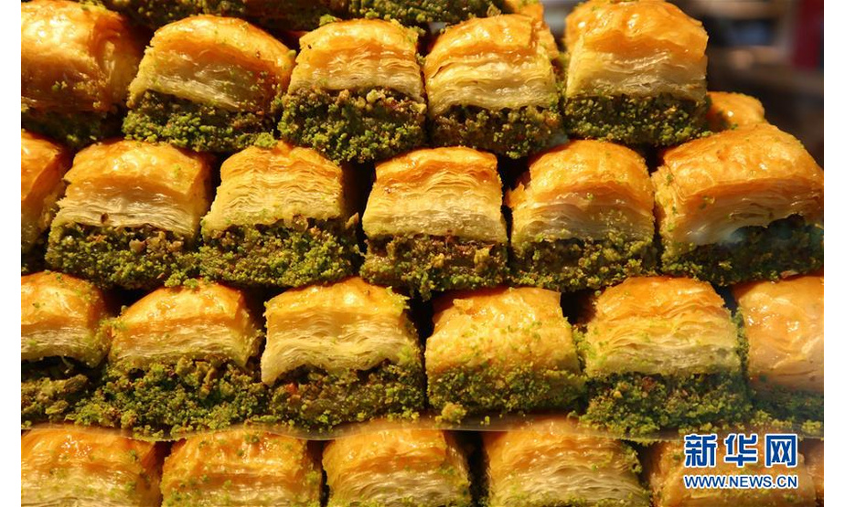 这是8月18日在土耳其伊斯坦布尔塔克西姆广场的一家甜品店拍摄的“巴克拉瓦”。果仁蜜饼“巴克拉瓦”是土耳其民众最喜爱的传统甜点之一。“巴克拉瓦”用糖浆或蜂蜜调味，中部是切碎的果仁，上下是多层用油脂起酥的酥皮，有方形、菱形和三角形，吃下去口感酥松香脆、甜蜜芬芳。 在土耳其，售卖“巴克拉瓦”的店铺遍布各个城市。无论是作为庆祝节日的盛宴上的佳肴，还是作为午后小憩的茶点，“巴克拉瓦”都深受民众欢迎。新华社记者 徐速绘 摄
