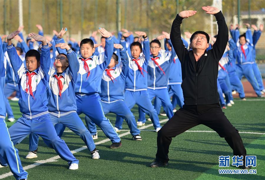 11月19日，沧州青县实验小学的学生在体育老师的指导下练习盘古王拳。 近年来，“武术之乡”河北省沧州市教育、体育部门对体育教师进行强化培训和技术指导，并根据青少年身心特点，编制融合当地特色拳种特点的系列武术教材，持续推进传统武术进校园活动。 新华社记者 王民 摄