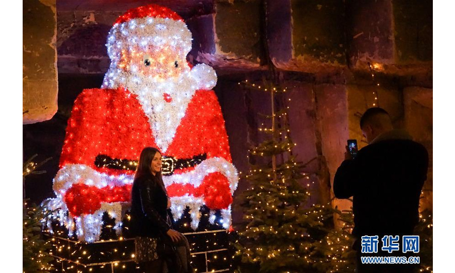 12月8日，在荷兰法尔肯堡，游客在地下圣诞市场的圣诞老人灯饰前留影。新华社记者林立平摄