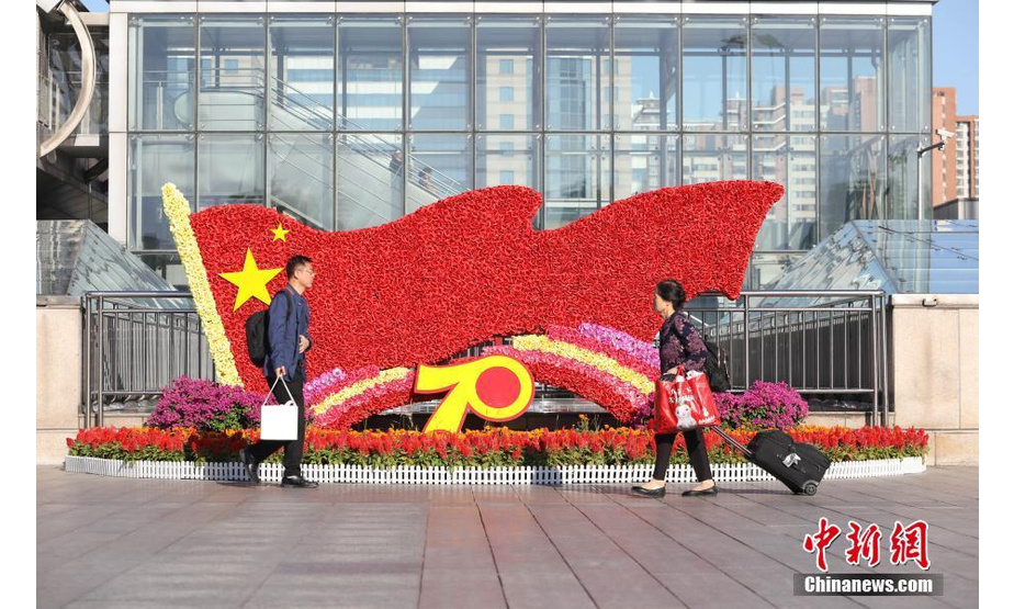 9月18日，市民在北京西单街头的主题花坛前自拍。随着国庆节临近，北京街头主题花坛陆续亮相，吸引市民驻足观赏拍照。