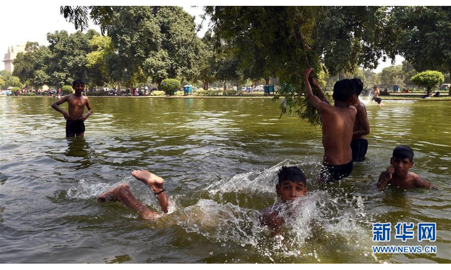 6月7日，在印度首都新德里，男孩在水池内玩耍。 自印度国家气象局2日发布高温预警以来，印度多地持续高温天气。 新华社记者张迺杰摄