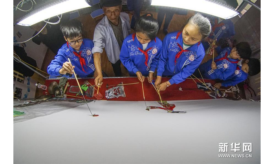 6月13日，民间艺人在大漫港小学辅导学生表演皮影戏。新华社发（刘满仓 摄）