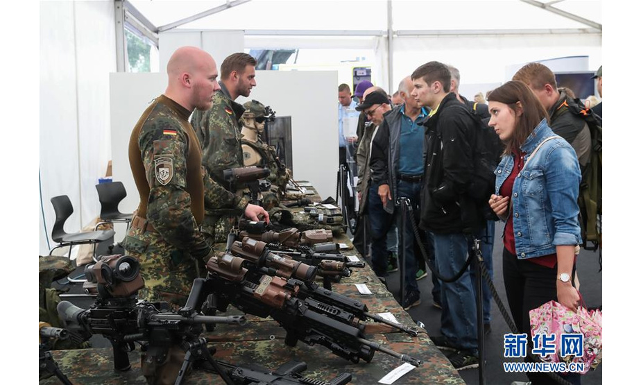 8月18日，在德国首都柏林，两名德国联邦国防军成员向参观者介绍武器装备。新华社记者 单宇琦 摄