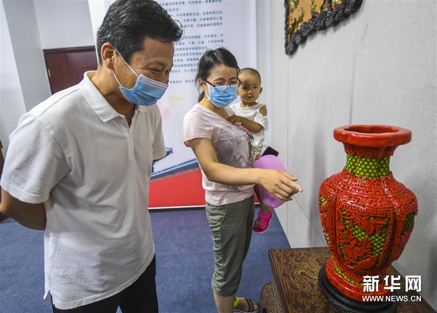 为促进非物质文化遗产的保护、传承和发展，河北省廊坊市在市群艺馆设立非遗展厅展示“燕京八绝”等非遗展品，展现非遗传承人的高超技艺，同时让群众近距离领略非遗魅力。图为7月4日，人们在廊坊市群艺馆参观雕漆工艺品。新华社记者 李晓果 摄