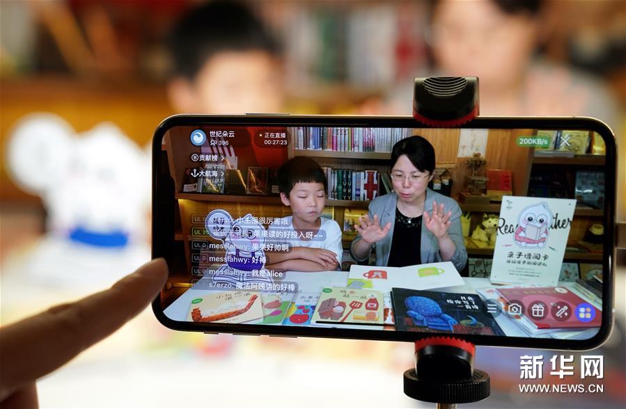6月1日，在上海思南书局复兴中路店，7岁的小读者果果与儿童文学作家、魔法童书会创始人张弘在绘本阅读的直播中。 新华社记者 刘颖 摄