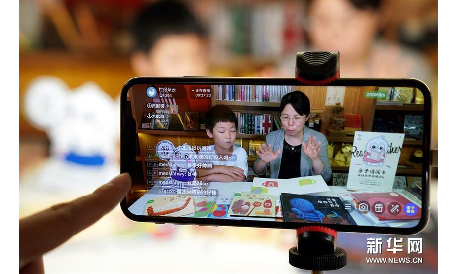 6月1日，在上海思南书局复兴中路店，7岁的小读者果果与儿童文学作家、魔法童书会创始人张弘在绘本阅读的直播中。 新华社记者 刘颖 摄