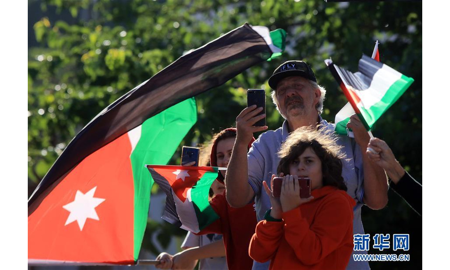 5月25日，在约旦首都安曼，居民挥舞国旗观看军车巡游。 约旦25日举办军车巡游、烟花秀等活动庆祝国家独立日。约政府表示，考虑到防疫需要，今年没有举办大型庆祝集会，尽量让民众在家中感受节日氛围。约旦于1946年5月25日宣布脱离英国获得独立，阿卜杜拉一世登基为王（埃米尔），国名为约旦哈希姆王国。 新华社发（穆罕默德·阿布·古什摄）