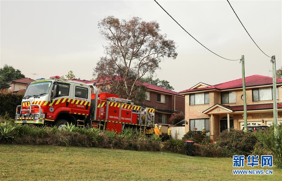 11月12日，在澳大利亚悉尼附近的南塔勒马拉，消防员向居民房屋喷水。 近日，澳大利亚东部林火继续肆虐，大悉尼地区面临“灾难级”林火威胁。悉尼所在的新南威尔士州州长贝雷吉克利安11日宣布该州进入为期7天的紧急状态。12日，最近的起火点已逼近悉尼城区，林火造成城市上空被大量烟尘笼罩。 新华社记者 白雪飞 摄