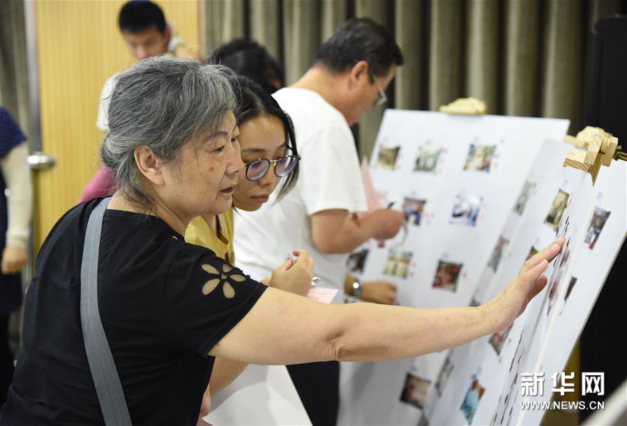 8月14日，社区群众代表为老照片投票。 当日，以“城市记忆·学院路故事”为主题的老物件、老照片展览评选活动在北京市海淀区学院路街道市民中心多功能厅举行。 据了解，本次活动共展出100余件老物件、100余张老照片，来自29个社区的代表组成的评审团对展品进行评选。活动旨在唤起社区居民的城市记忆，见证改革开放的巨大变化，进一步增强社会公众的档案参与意识、保护意识和利用意识。 新华社发（任超摄）