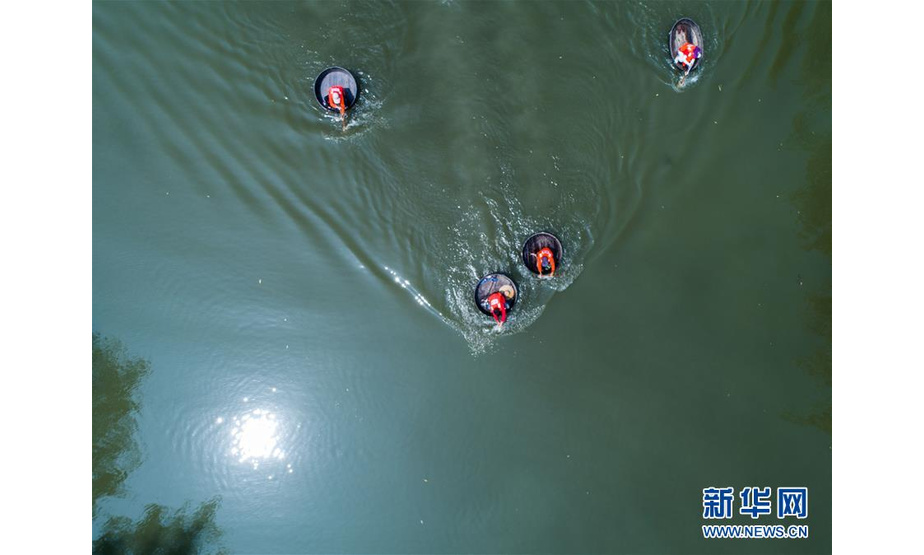 6月5日，村民们在泉益村滨水公园的河道内参加端午划菱桶趣味比赛（无人机拍摄）。 新华社记者 徐昱 摄