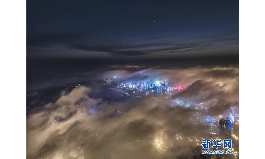 4月20日晚，无人机拍摄的青岛五四广场上空平流雾美景。当日晚，青岛五四广场毗邻的浮山湾出现平流雾，萦绕在夜晚建筑物间的雾气营造出流光溢彩的景观。 新华社发（卢晖 摄）