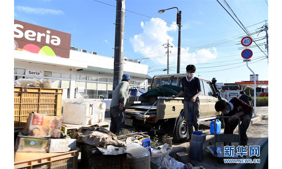 7月10日，在日本冈山县仓敷市真備町一家超市前，工作人员在整理浸过水的货物。日本西部地区连降特大暴雨，引发30多年来最严重水灾。据日本媒体汇总，截至7月10日上午，已有至少130人丧生，将近60人失联。新华社记者 马平 摄