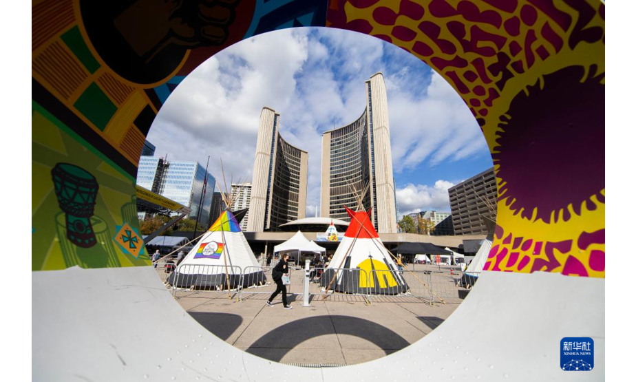 11月4日，在加拿大多伦多市政广场，行人走过原住民帐篷。新华社发（邹峥摄）