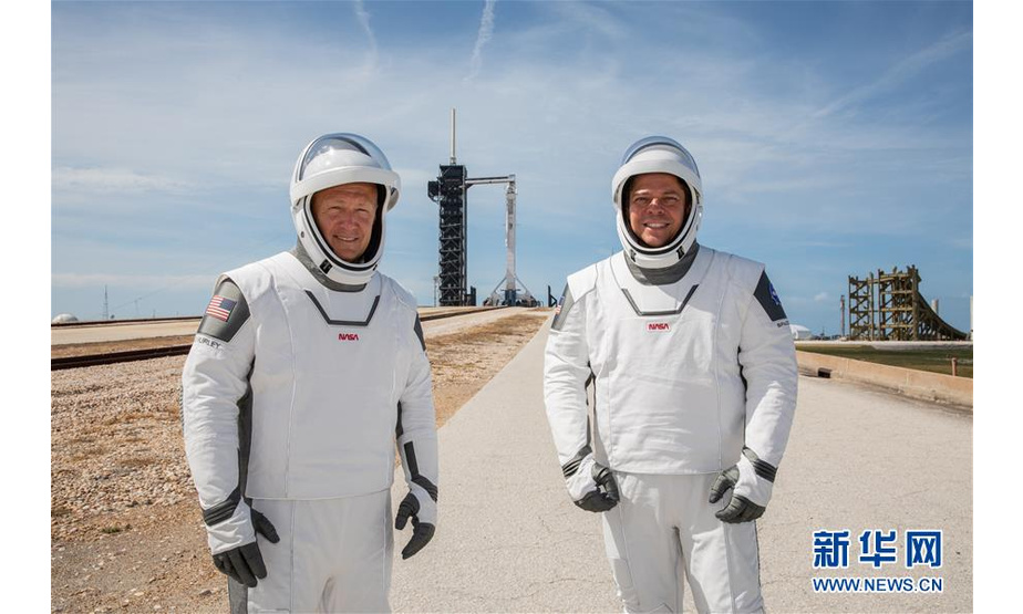 美国航天局原定于5月27日用载人版“龙”飞船将两名美国宇航员送往国际空间站，但因天气原因推迟。下一次发射窗口为美国东部时间30日15时22分（北京时间31日3时22分）。 这是5月23日，在美国佛罗里达州肯尼迪航天中心，宇航员道格拉斯·赫尔利（左）与宇航员鲍勃·本肯身着宇航服参与发射演练。 新华社发（美国国家航空航天局供图）