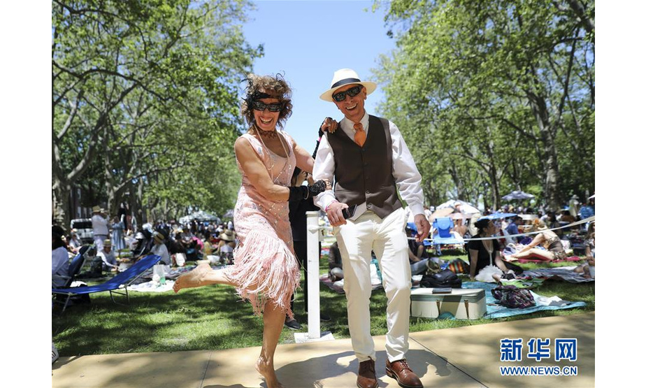 6月15日，人们在美国纽约举行的“爵士时代草坪派对”上跳舞。 当日，第14届“爵士时代草坪派对”在纽约市总督岛举行。这项始于2005年的活动以二十世纪二十年代的爵士风潮为主题，上千名参与者身着复古服饰，伴着爵士音乐或翩翩起舞，或席地野餐，享受“时光倒流”的别样乐趣。 新华社记者 邹广萍 摄