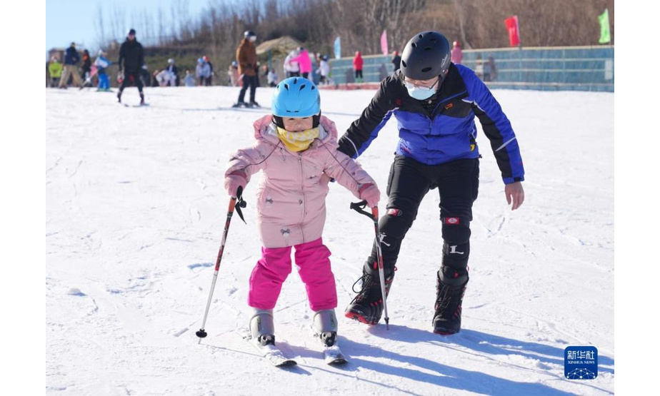 12月12日，一位家长带着孩子在河北省秦皇岛市海港区紫云山滑雪场练习滑雪。 入冬以来，河北省秦皇岛市海港区紫云山滑雪场迎来众多滑雪爱好者，体验雪上运动的乐趣。 新华社记者杨世尧摄