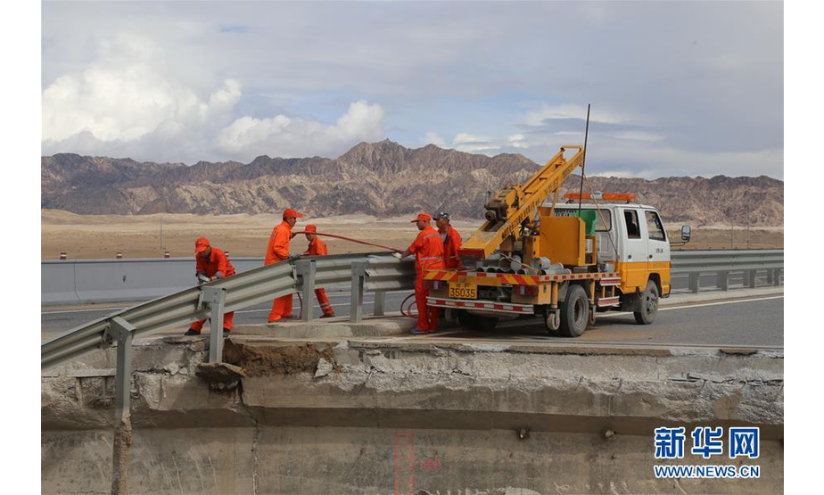 7月7日，甘肃省酒泉公路局职工在水毁路段整修护栏。 新华社发（李亚宁 摄）