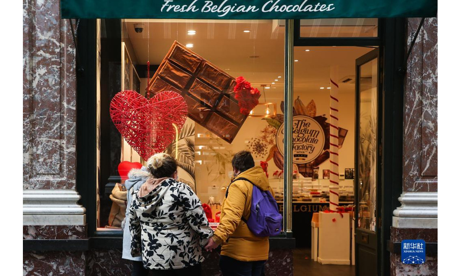 2月8日，在比利时布鲁塞尔的一家巧克力商店橱窗外，人们被“情人节”主题巧克力吸引。

　　随着2月14日情人节的临近，比利时巧克力商家近日陆续推出各色新品，吸引顾客。比利时巧克力蜚声世界，享有“巧克力王国”的美誉。新华社记者 郑焕松 摄
