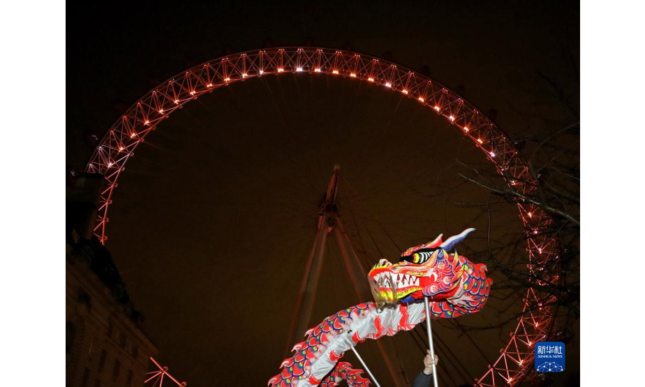 1月28日，在英国伦敦，演员在亮起“中国红”的“伦敦眼”前表演舞龙。

　　28日晚，英国伦敦地标建筑、巨型摩天轮“伦敦眼”亮起红色灯光，迎接中国农历新年的到来。

　　新华社记者 李颖 摄