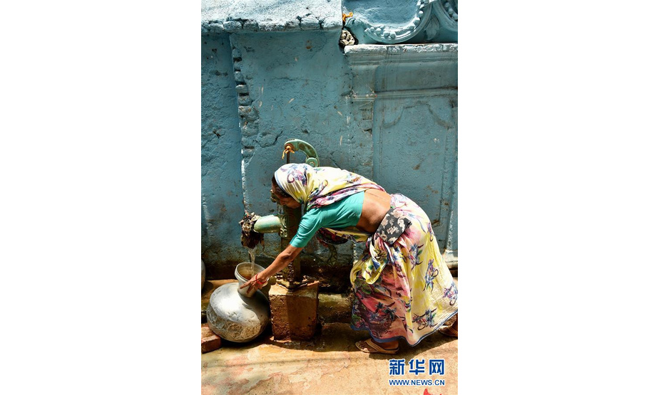 5月20日，在孟加拉国首都达卡，一名女子将水罐放在管井处取水。由于近一个月的热浪侵袭以及几乎没有降雨，孟加拉国首都达卡老城区市民面临供水危机。新华社发