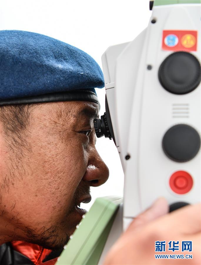 自然资源部第一大地测量队队员郑林在使用全站仪对珠峰峰顶进行交会观测（5月27日摄）。 当日，2020珠峰高程测量登山队成功登顶后，在珠峰大本营的珠峰高程起算点，自然资源部第一大地测量队队员利用全站仪等仪器对珠穆朗玛峰峰顶进行交会观测。 新华社记者 晋美多吉 摄