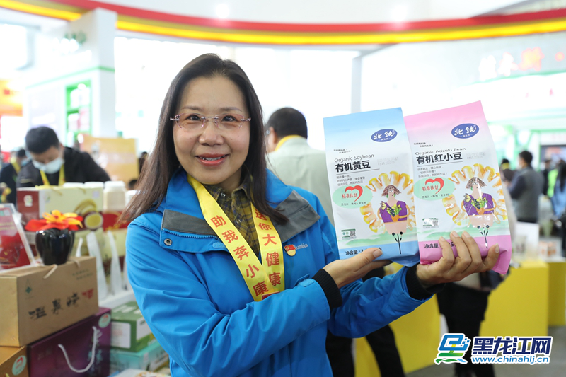 黑龙江网10月18日讯（记者 韩俏 白林鹤 石岩松）今日，在第八届黑龙江绿色食品产业博览会和第三届中国∙黑龙江国际大米节上，我省驻村“第一书记”纷纷为本地的各类优质扶贫产品推广代言，并借助“黑龙江国际大米节”的平台为产品寻找商机。图为黑龙江省人大常委会办公厅驻林甸县四季青镇宏丰村第一书记荣丽颖为北纯有机黄豆代言。