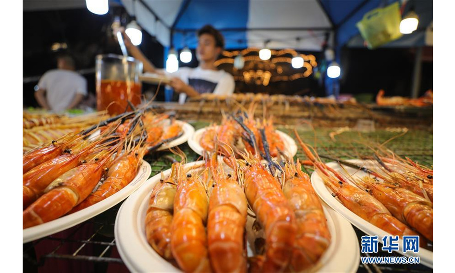 8月10日，在泰国曼谷河滨夜市，商贩在售卖烤虾。 夜幕之下，多姿多彩的夜生活让曼谷这座城市充满活力。 新华社记者 张可任 摄