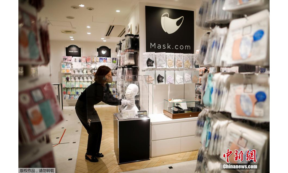 当地时间11月25日，日本一家口罩专卖店推出售价100万日元的奢华口罩，口罩上镶嵌了一颗重0.7克拉的钻石、铂金和施华洛世奇水晶等饰品。图为工作人员正在整理店内陈设的口罩。
